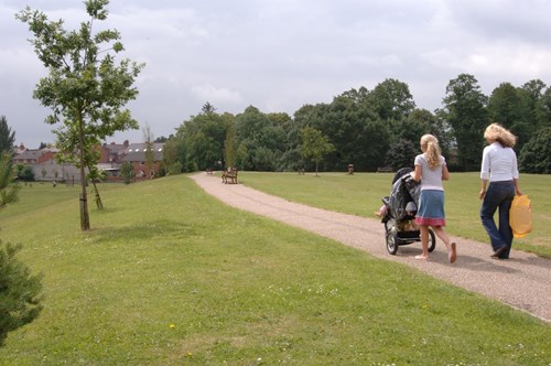 Pobol yn cerdded yn parc dinas yn Wrecsam